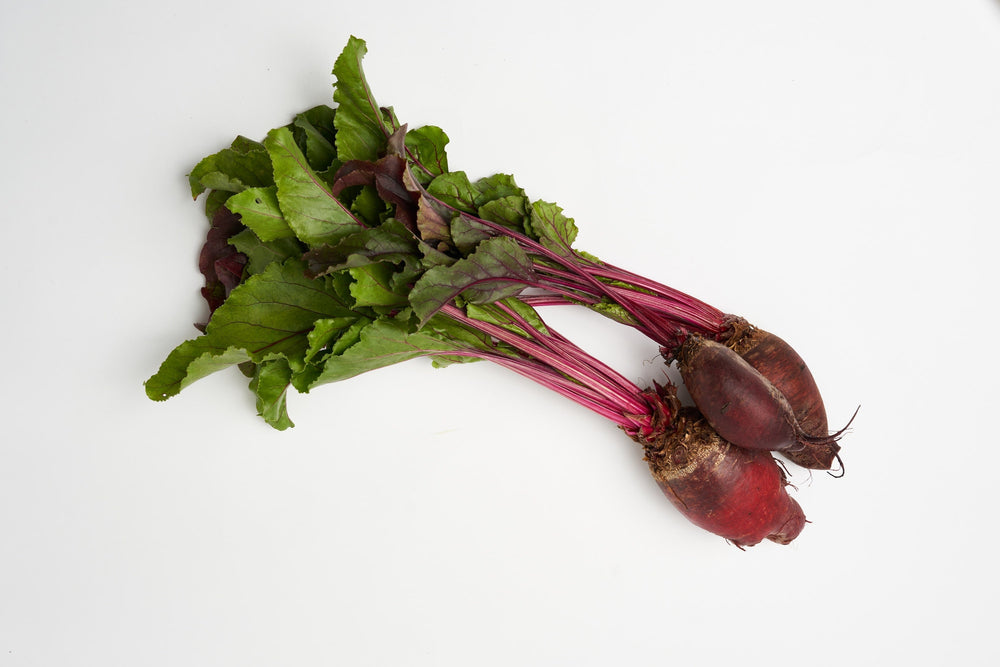 Bunch of beets with green leaves on a white background